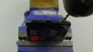 Image showing iPhone 7 being drilled in to for non existent headphone jack.