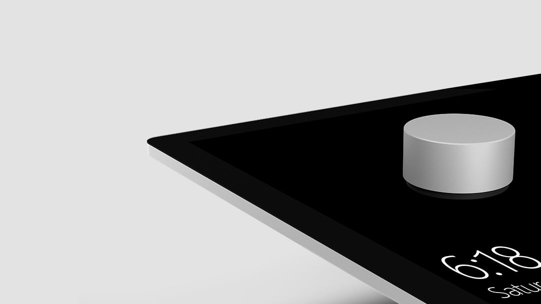 Image of Surface Dial on top of a touch screen displaying the time.